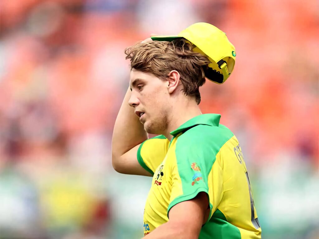 Australian cricketer Cameron Green in yellow green uniform bats on field with focused expression Wallpaper