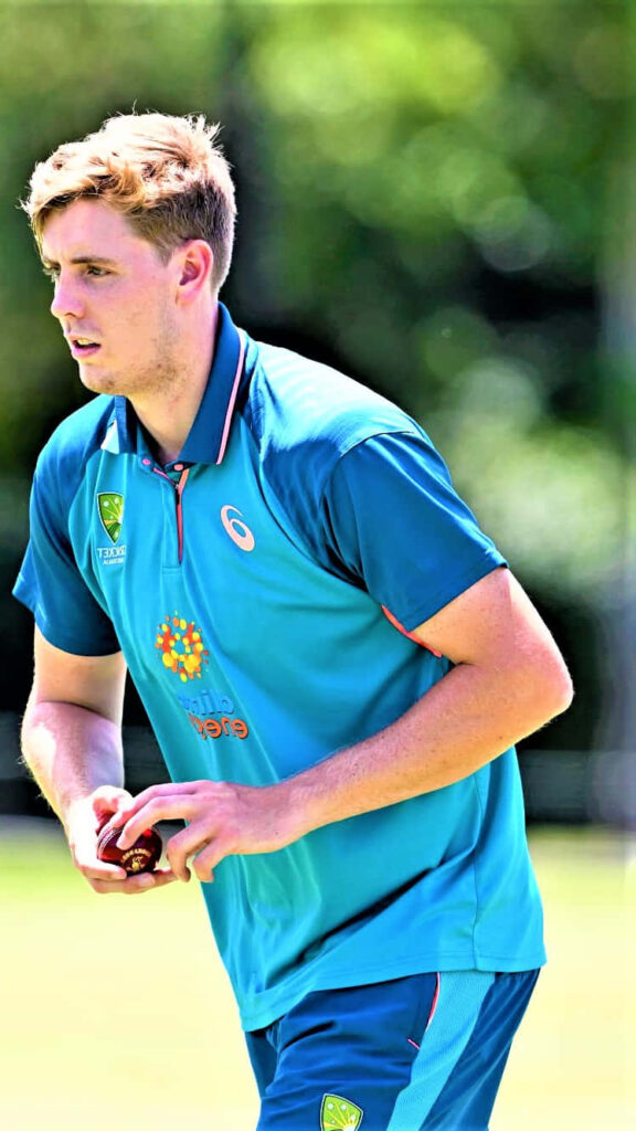 Cameron Green Australian cricketer in official training kit on lush green cricket field wallpaper
