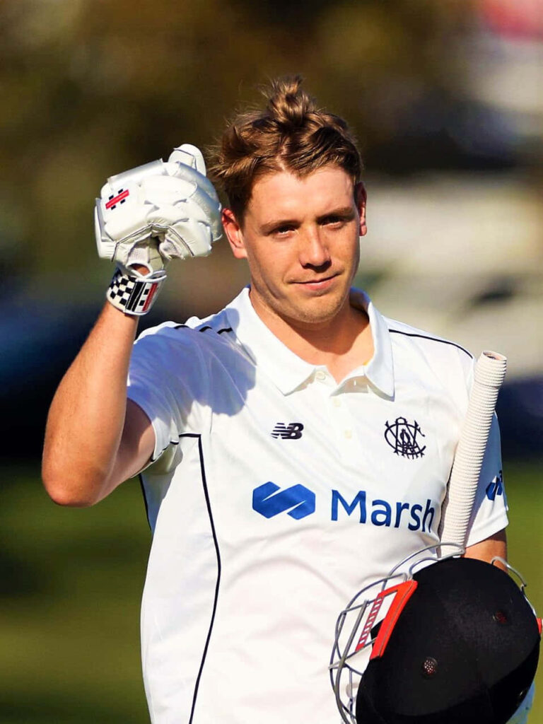 Cameron Green Australian cricketer in white uniform holding helmet and gloves on field Wallpaper