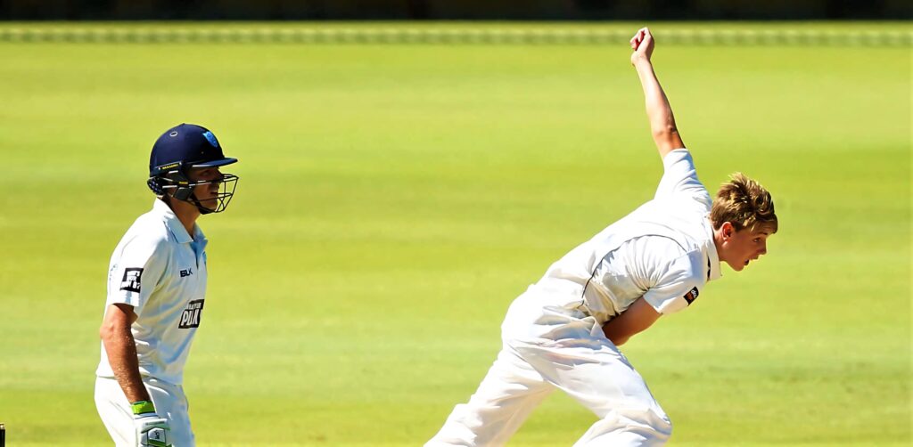 Cameron Green bowling dynamically on bright green cricket pitch in intense high resolution action Wallpaper