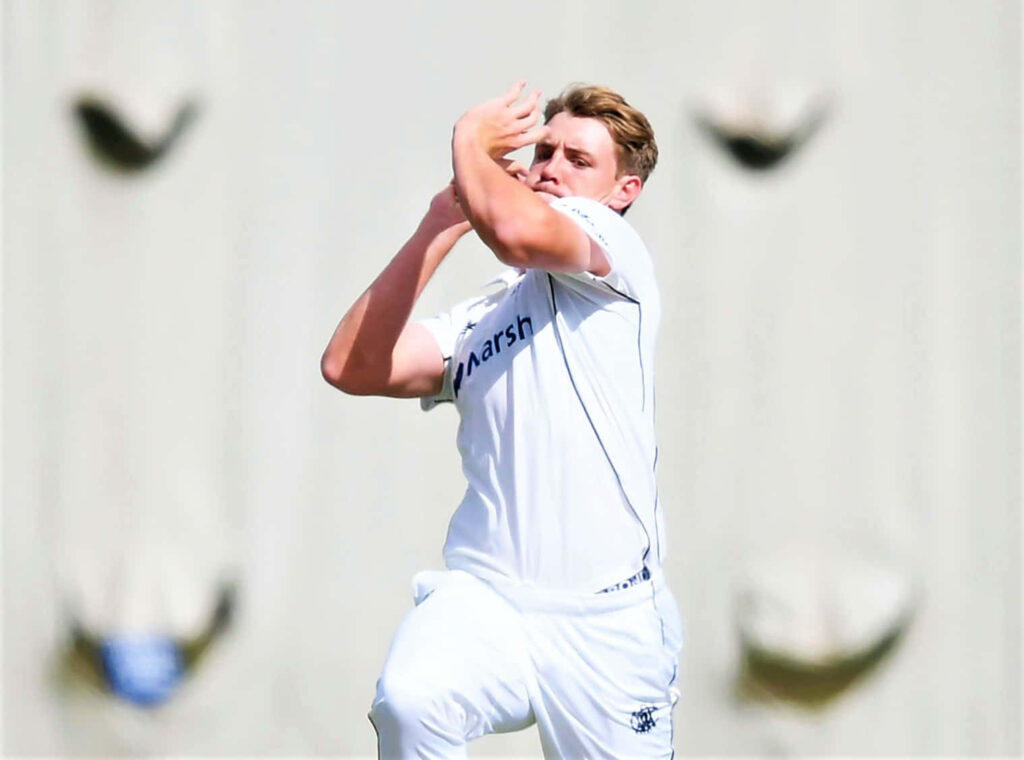 Cameron Green bowling in white cricket uniform showing focus and athletic form in action Wallpaper