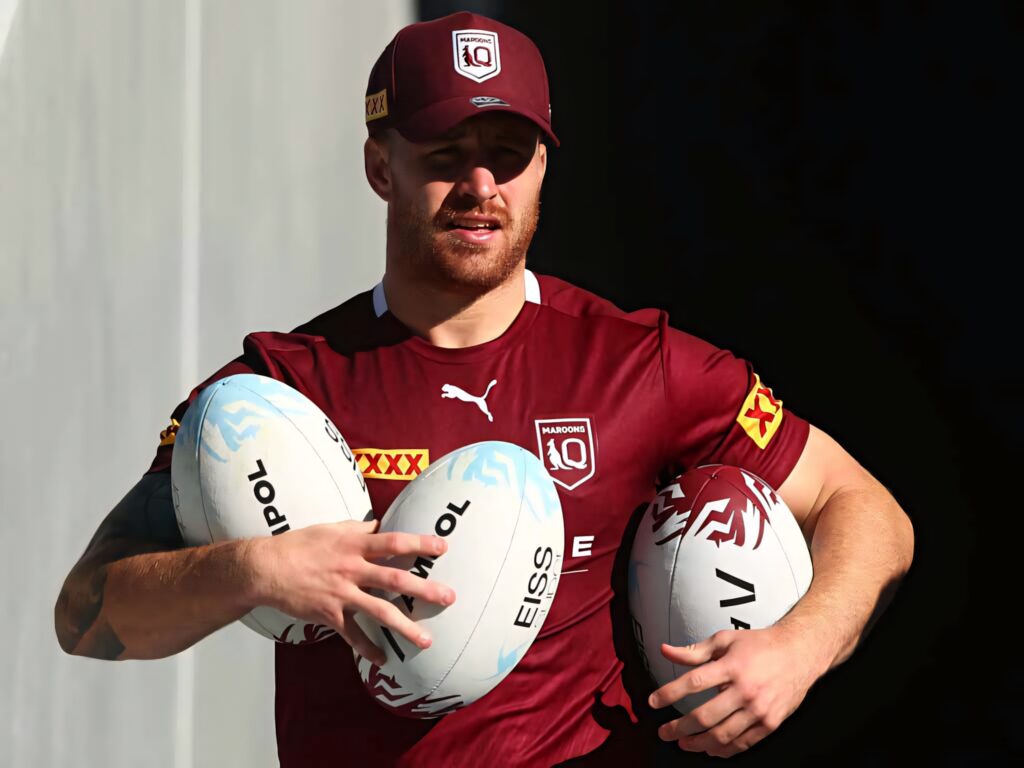 Cameron Munster in maroon Queensland jersey holding three rugby balls showing rugby league intensity Wallpaper