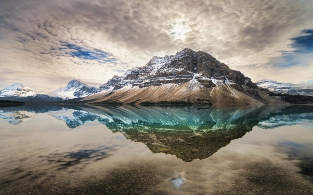 Reflective Tranquility: Majestic Snowy Peaks grace the Calm Lake in Canadian Rocky Mountain Landscape Wallpaper