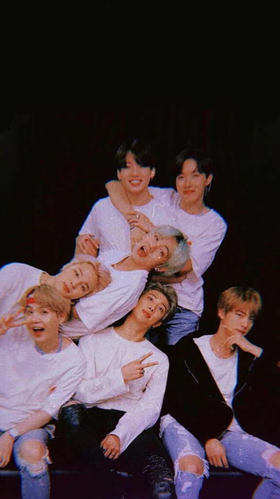 Adorable BTS Band Strikes a Pose against a Captivating Black Background Wallpaper