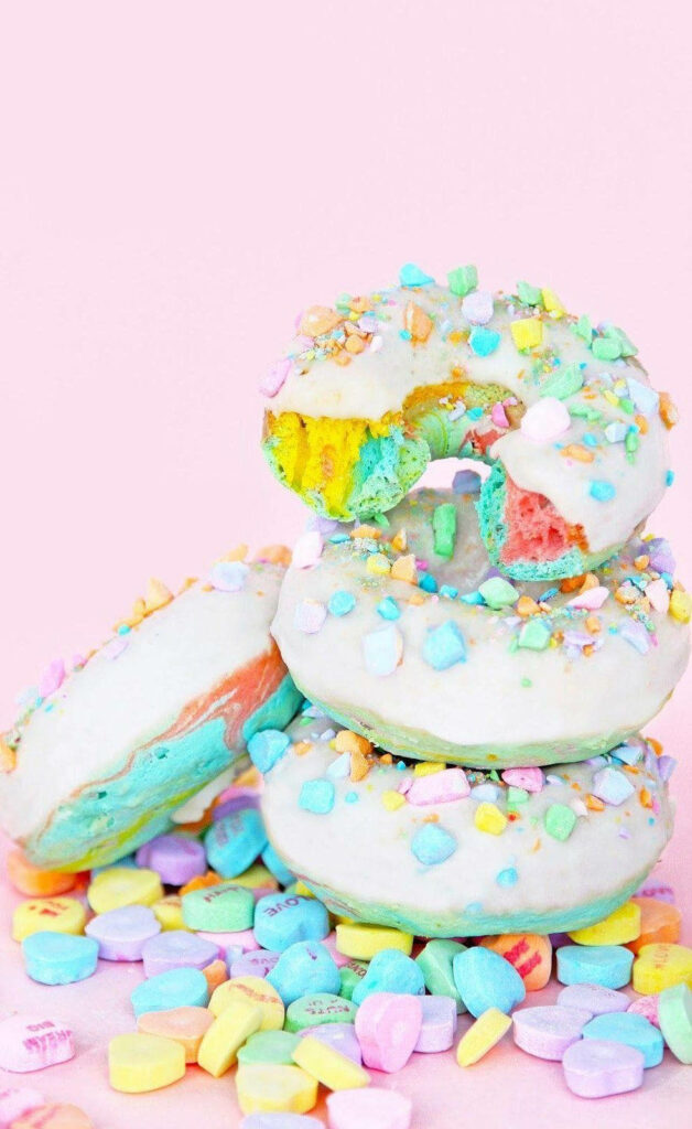 Sweet Treats: Delectable iPhone Wallpaper featuring Vibrant Cookies and Candy Hearts on a Pink Background