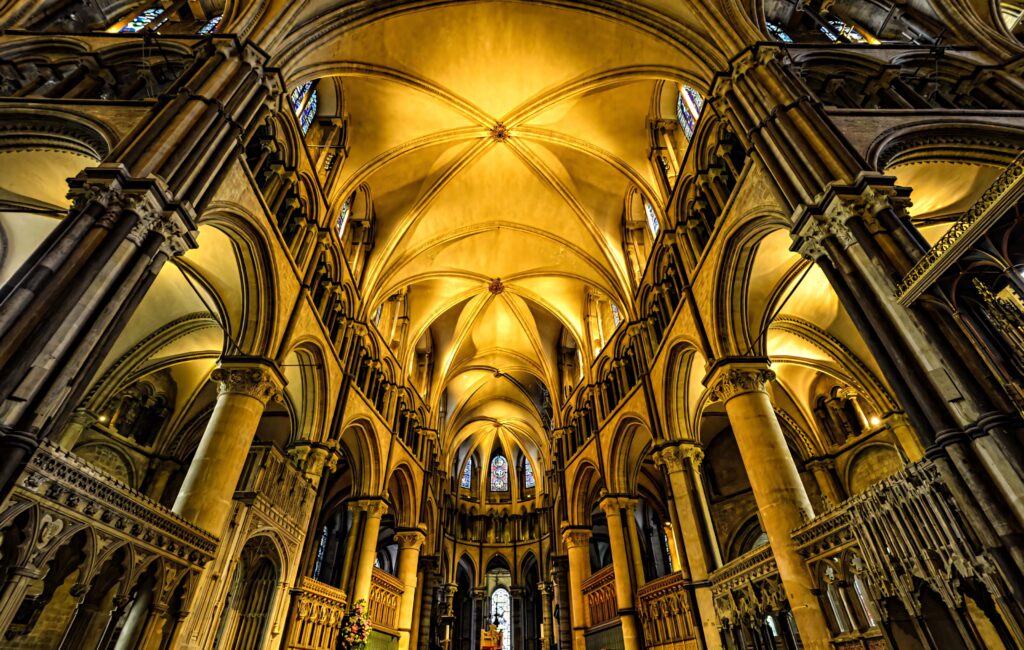 Canterbury Cathedral ceiling wallpaper with Gothic arches golden lighting and intricate stonework