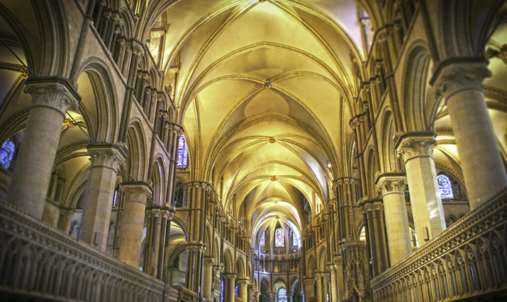 Canterbury Cathedral interior with soaring stone arches intricate columns and stained glass windows Wallpaper
