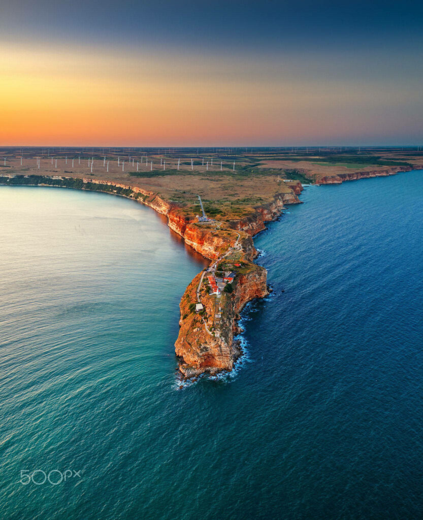 Aerial view of Cape Kaliakra red cliffs Bulgaria sunset sea and wind turbines on horizon wallpaper