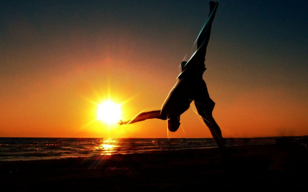 Capoeira Fighter's Elegant Flip at Sunset - Vibrant Ocean Wallpaper