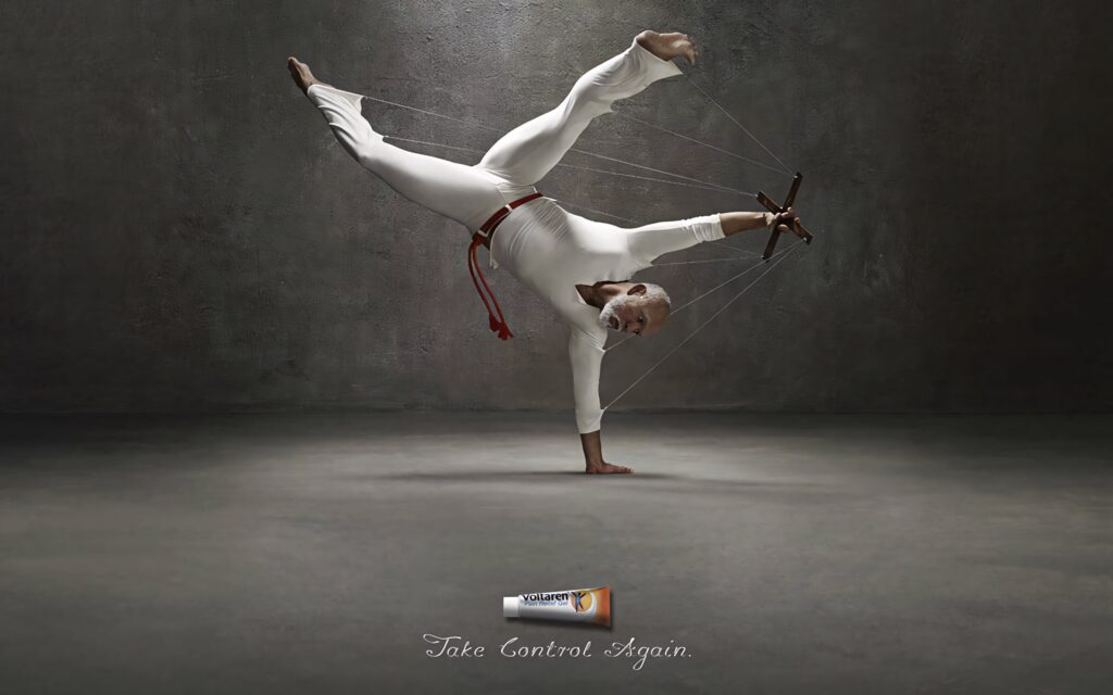Capoeira performer balancing on one hand controlled by puppet strings symbolizing freedom Wallpaper