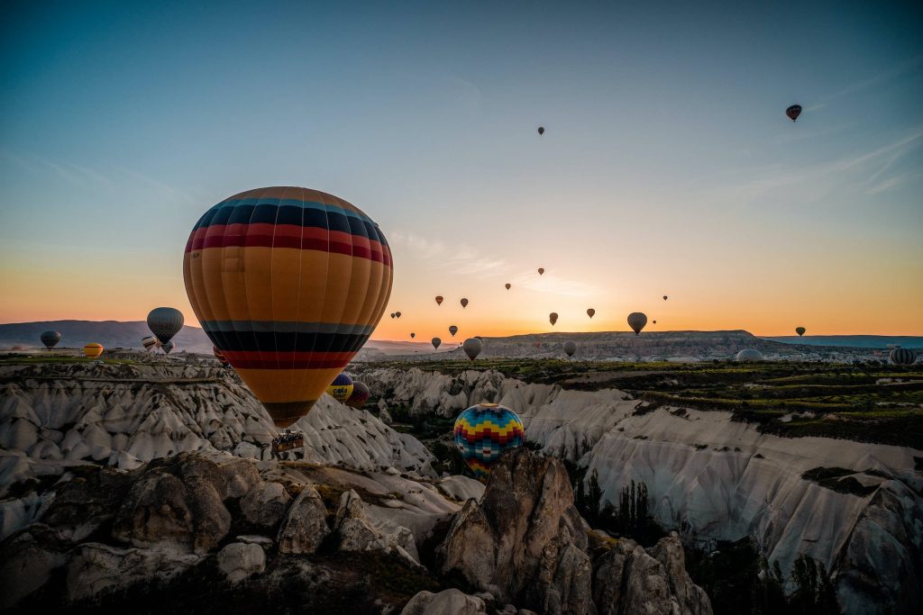 Vibrant Cappadocia hot air balloon over rugged Turkish rock formations at sunrise wallpaper