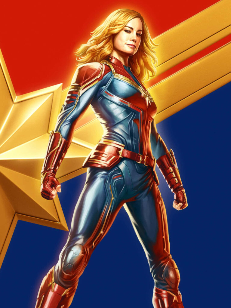 Captain Marvel Brie Larson in vibrant red blue gold suit with star background on red carpet Wallpaper