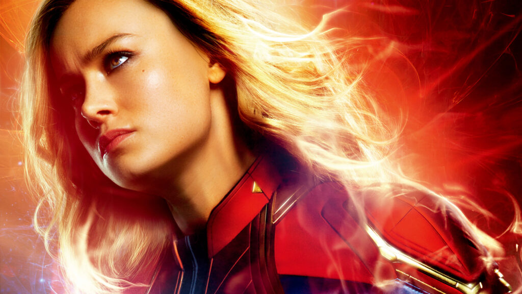 Captain Marvel Brie Larson red dress cosmic background glowing light effects heroic close-up Wallpaper