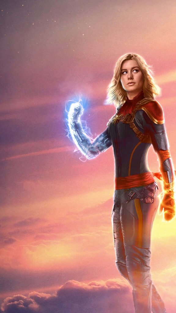 Captain Marvel Brie Larson in iconic suit with glowing energy and vibrant sunset sky background Wallpaper