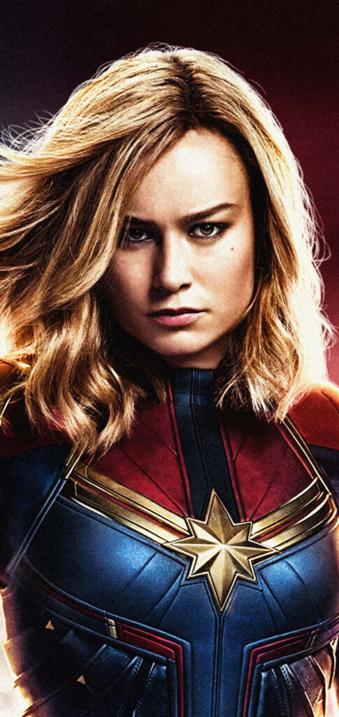 Captain Marvel Brie Larson in red blue gold suit confident pose vibrant floral background wallpaper