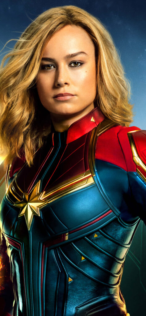 Captain Marvel Brie Larson in red blue gold suit striking pose vibrant studio backdrop wallpaper