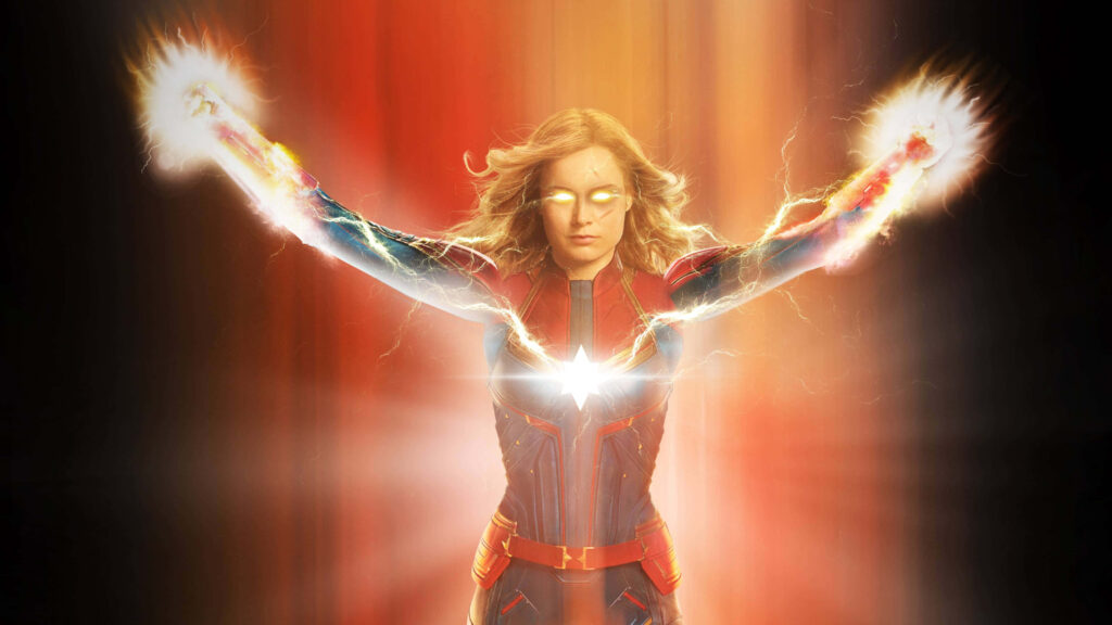 Flying High: Brie Larson takes flight as Captain Marvel, harnessing her superpowers against a captivating backdrop Wallpaper