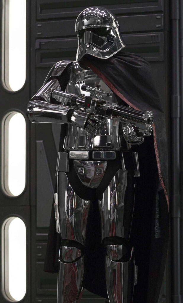 Captain Phasma close-up in chrome armor with blaster and black cape industrial Star Wars background Wallpaper