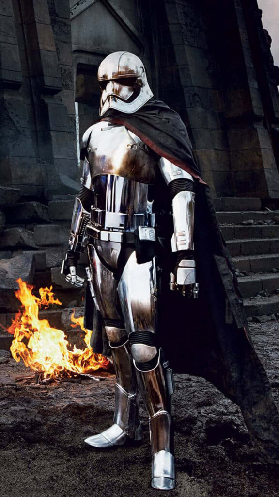 Captain Phasma in shiny chrome armor with black cape against fiery stone Star Wars wallpaper background