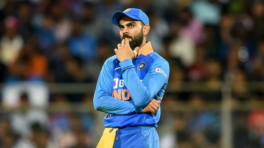 Revving Up the Cricket Passion: Captain Virat Kohli in Deep Contemplation Amidst Stadium Roar - Wallpaper