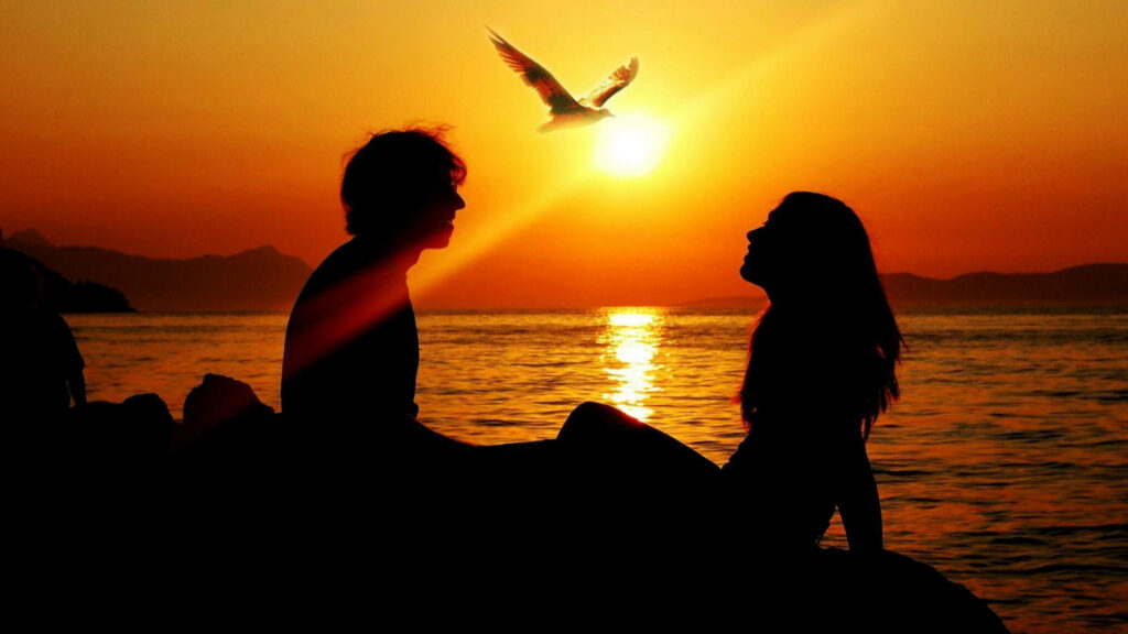 Embracing the Sunset: A Enchanting Encounter of Love and Romance Wallpaper