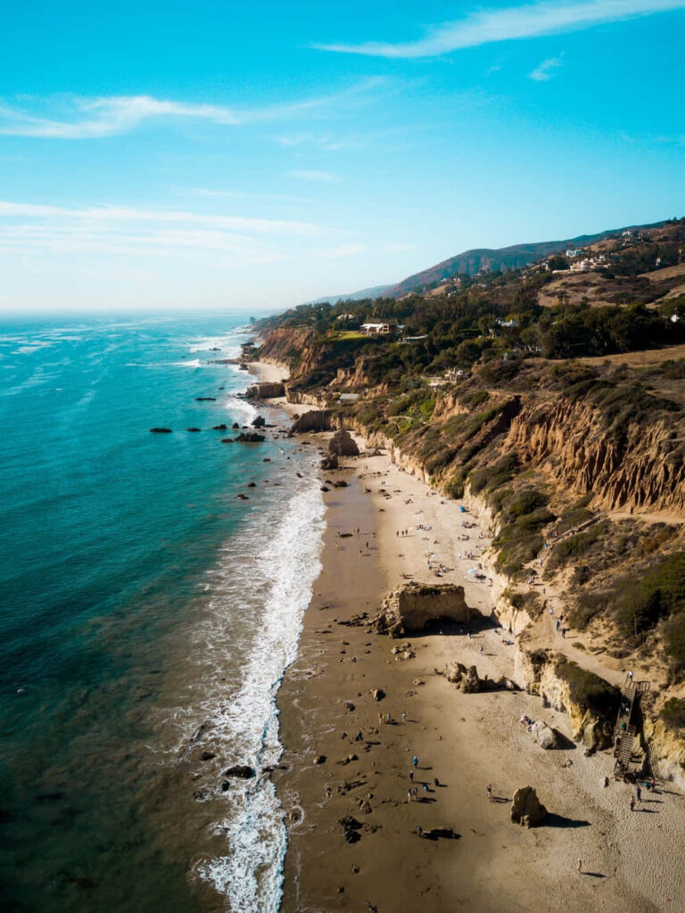Coastal Vista: El Matador State Beach Surrounded by Majestic Mountains Wallpaper