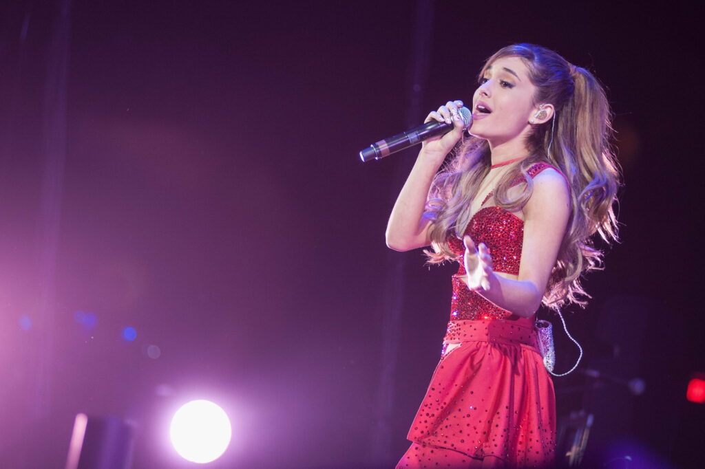 Ariana Grande live concert wallpaper red sparkling dress purple stage lighting musical performance
