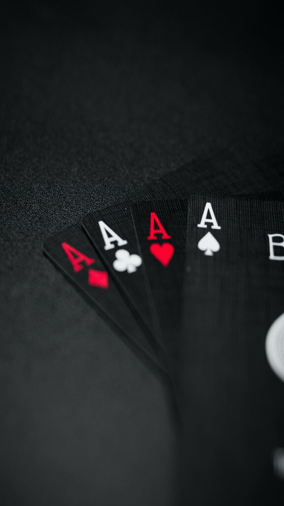 Captivating Tilt-Shift Lens Photo: A Striking Full HD Wallpaper Showcasing the Black Ace Cards in Four Suits