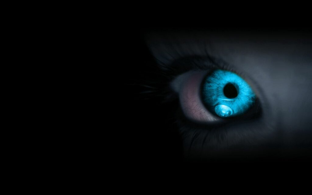 Close-Up Blue Eye Wallpaper: Intense Gaze on Black Background