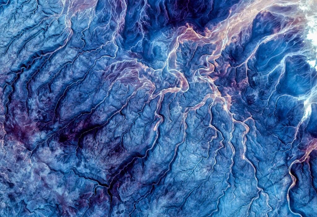 Abstract blue marble geological landscape wallpaper with navy purple river textures aerial view