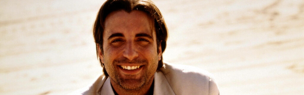 Aquatic Bliss: Andy Garcia Radiantly Grinning Against a Serene Waterscape Wallpaper
