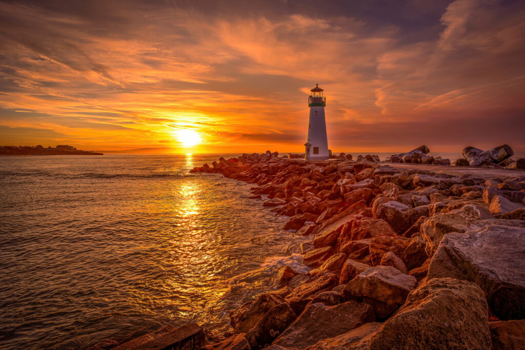 Walton Lighthouse at sunset on rocky jetty Santa Cruz coastal scenery HD wallpaper background