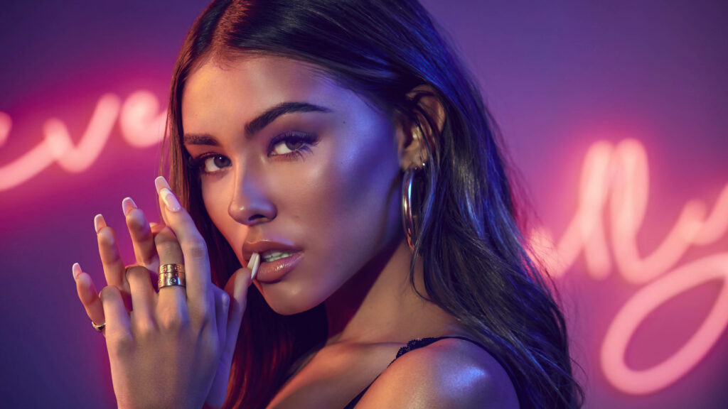 Captivating Coolness: Madison Beer Strikes a Pose, Gazing Confidently amidst Vibrant Neon Vibes Wallpaper