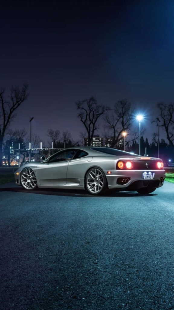 Unleashing the Elegance: The Alluring Red Ferrari 360 Modena Embraces the Darkness, Showcasing its Bold Design and Seductive Curves. A Treat for Auto Enthusiasts and Ferrari Lovers. Wallpaper