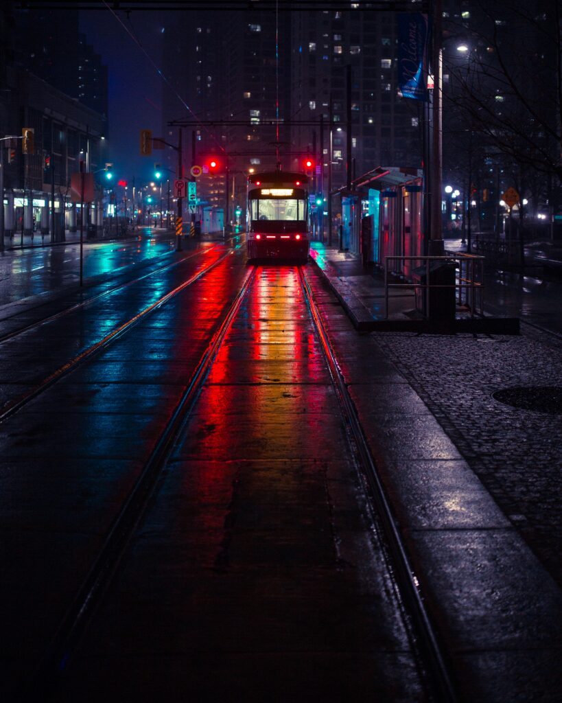 Vibrant Evening Cityscape: Trolley on Reflective Wet Streets Wallpaper