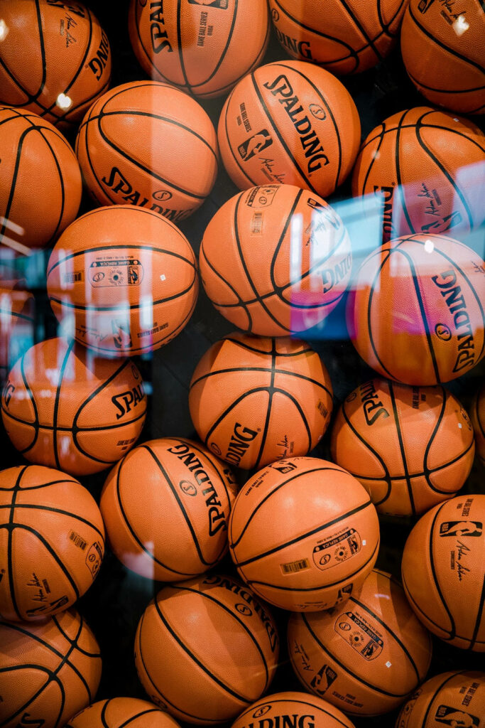 Score-Ready Hoops: Vibrant Display of Spalding Basketballs in Transparent Storage Wallpaper