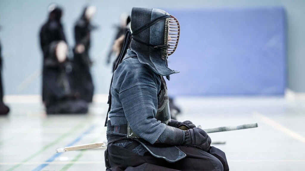 Kendo Wallpaper: Focused Practitioner in Traditional Armor Background