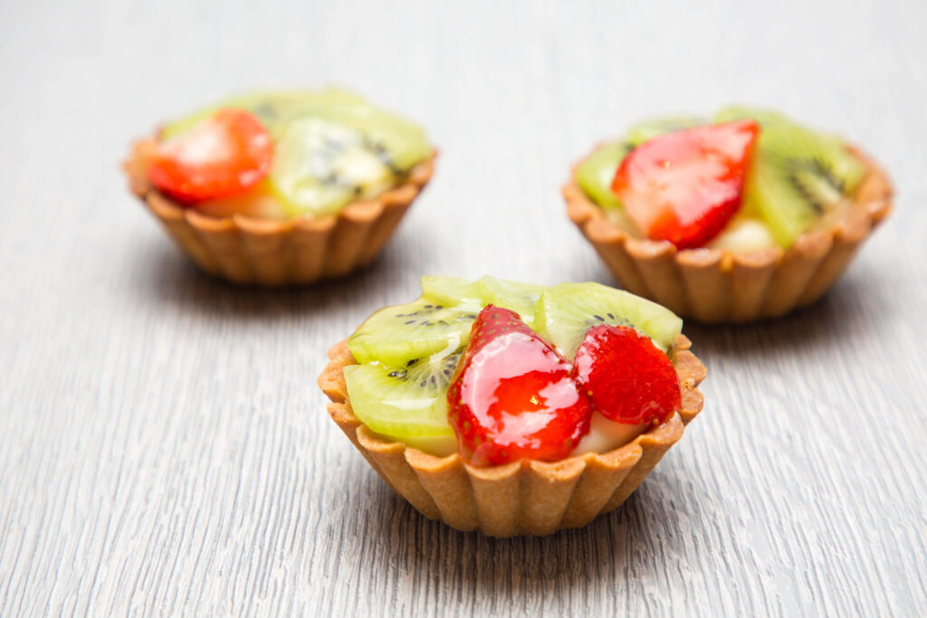 Delicious Mini Berry Tarts Captured in a Beautiful Table Setting Wallpaper