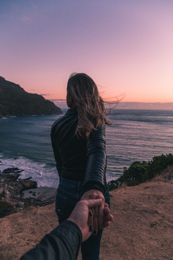 Romantic Coastal Escapade: Grasping Love at the Ocean's Edge Wallpaper