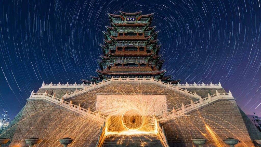 China's Dazzling Fireworks Display: An HD Night-Time Lapse Wallpaper Capturing Stunning Stars and Building Background.