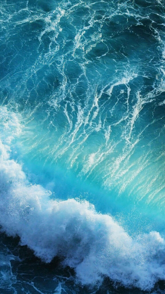 Gorgeous Seaside Serenity: Breathtaking Blue Ocean Waves Crash on White Foamy Shores Wallpaper