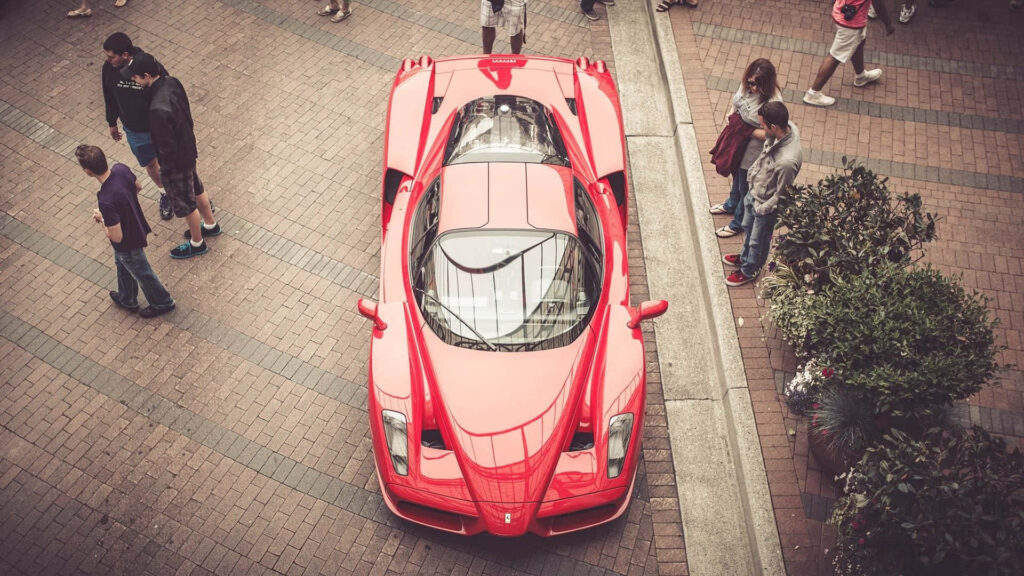 Exquisite Power in Motion: A Captivating Red Ferrari Enzo Embodies Performance and Luxury on the Road Wallpaper