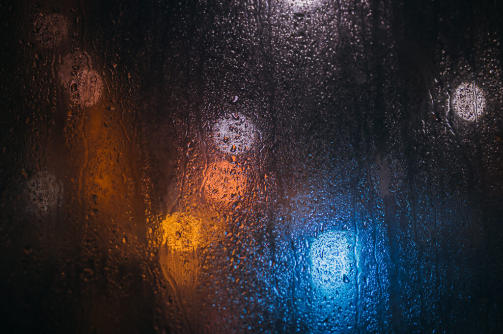 Serene Rain Droplets Wallpaper: Atmospheric Macro with Blurred Lights