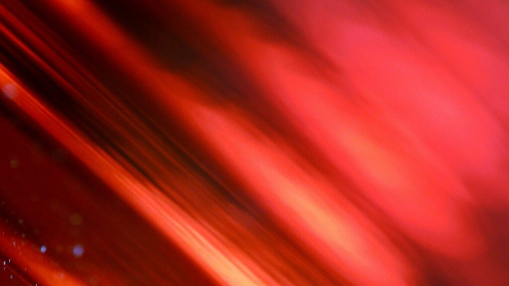 QHD abstract wallpaper with glowing red and orange diagonal streaks and smooth motion blur