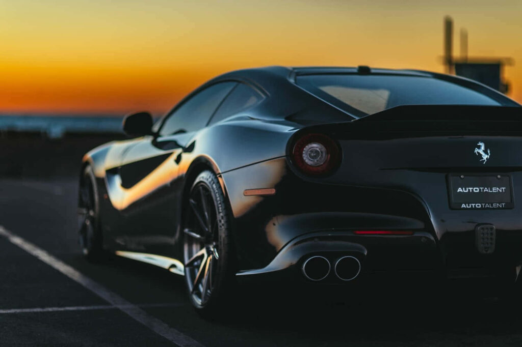 Black Ferrari F12 Berlinetta Against a Sunset-Sky Background Wallpaper