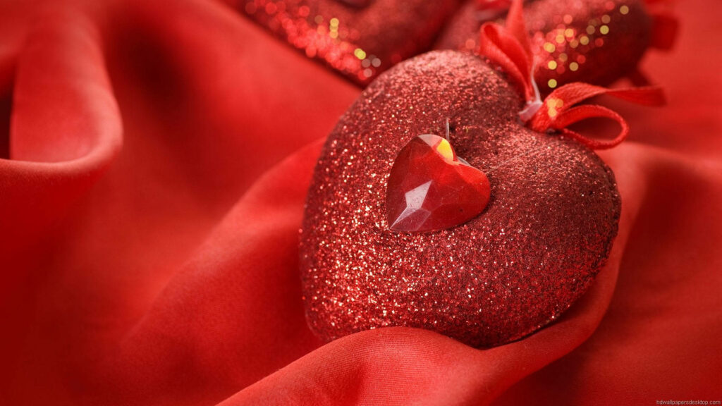 Glimmering Love: A Stunning High Definition Background Capture of a Ruby Glitter Heart Ornament on Luxurious Crimson Satin Wallpaper