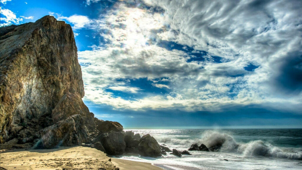 Majestic Malibu: An Immersive Cliffside Spectacle Amidst Gentle Coastal Waves Wallpaper