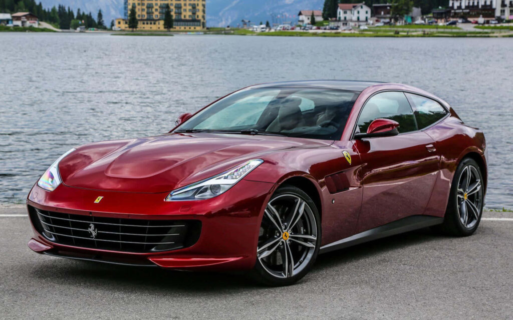 The Art of Automotive Excellence: Exquisite Red Ferrari GTC4Lusso in Motion on an Enchanting Open Road Wallpaper