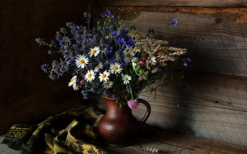 Serene Still Life: A HD Wallpaper of a Pitcher, Daisy Flower, Scarf, and White & Blue Flowers set against a peaceful background