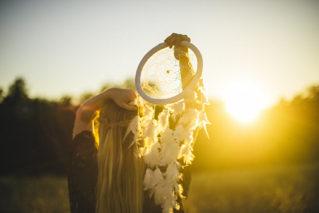 Dreamy Sunset Serenade: A Captivating HD Wallpaper of a Girl Admiring a Gorgeous Dreamcatcher in the Background